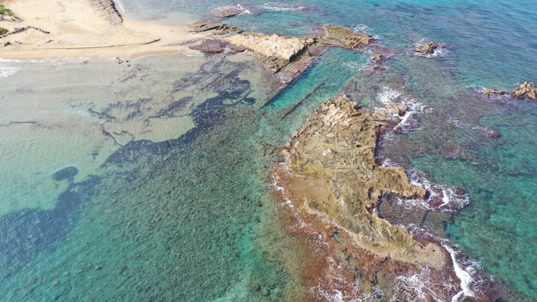 Aerial view of turquoise waters and rocky coastline in Mallorca at sunset