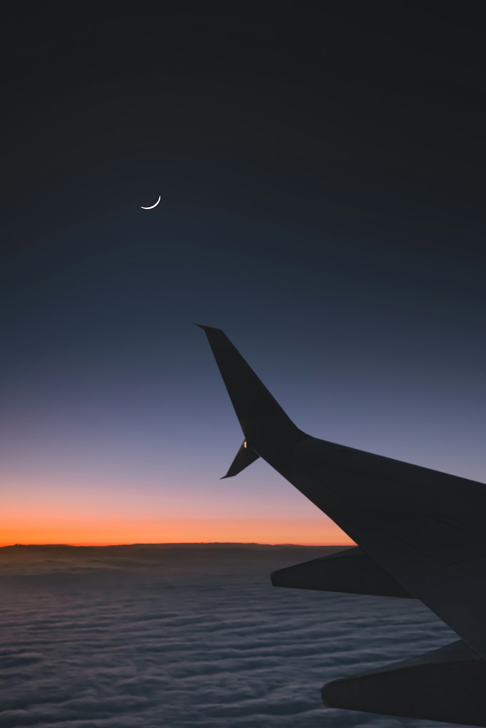 Flugzeug fliegt während des Sonnenuntergangs über die Wolken
