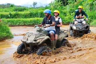 2 men riding atv on dirt road during daytime