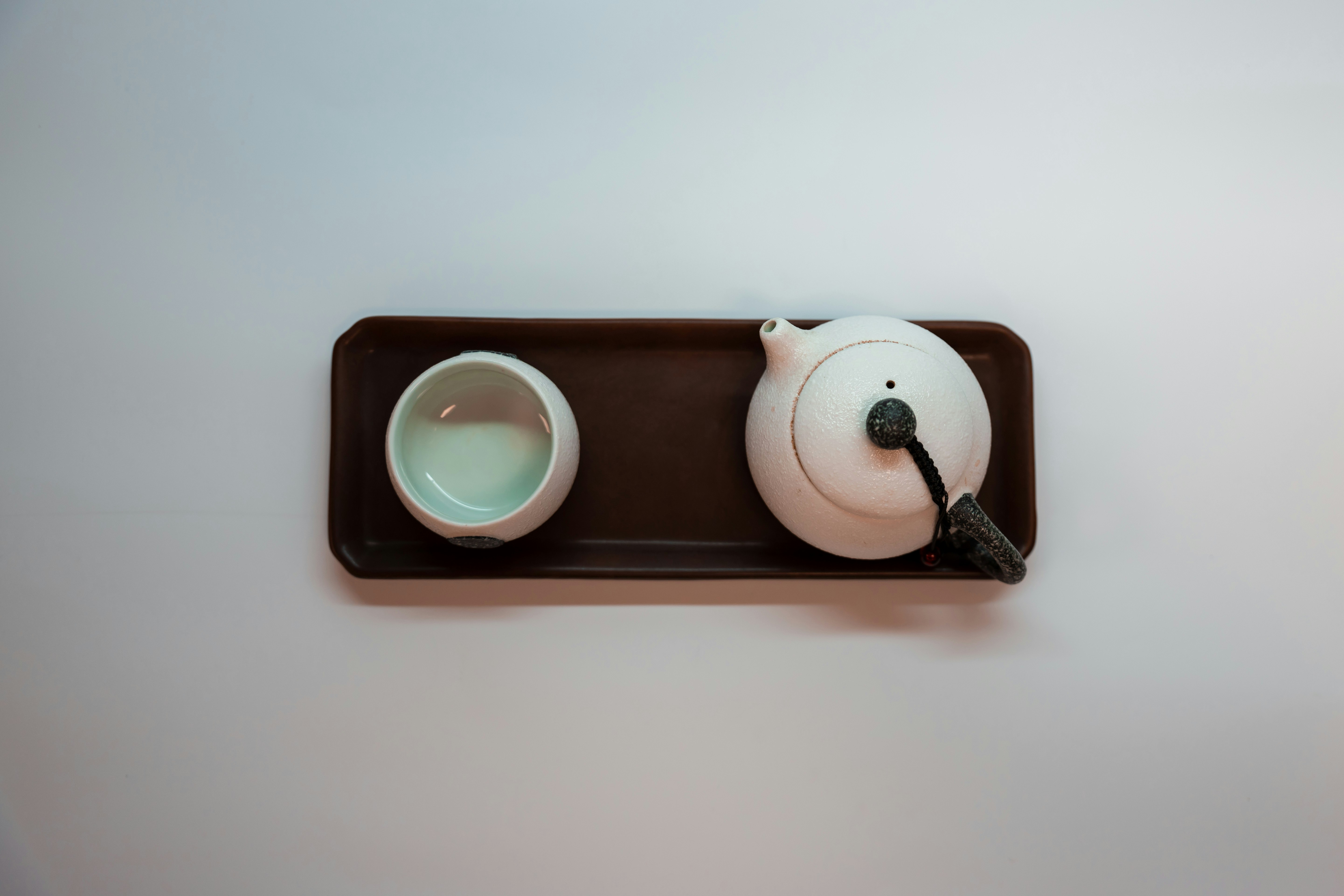 white ceramic mug with coffee on white ceramic saucer
