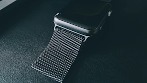 A sleek, modern product shot of a high-end smartwatch on a reflective surface with soft lighting highlighting its design.