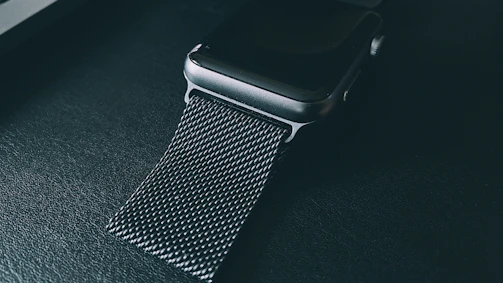 Close-up of a sleek, green-accented wearable tech piece glowing softly in dim light.