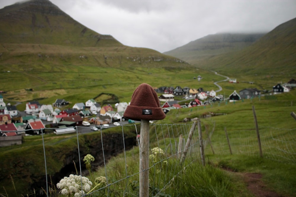 houses on green grass field near mountain under cloudy sky during daytime