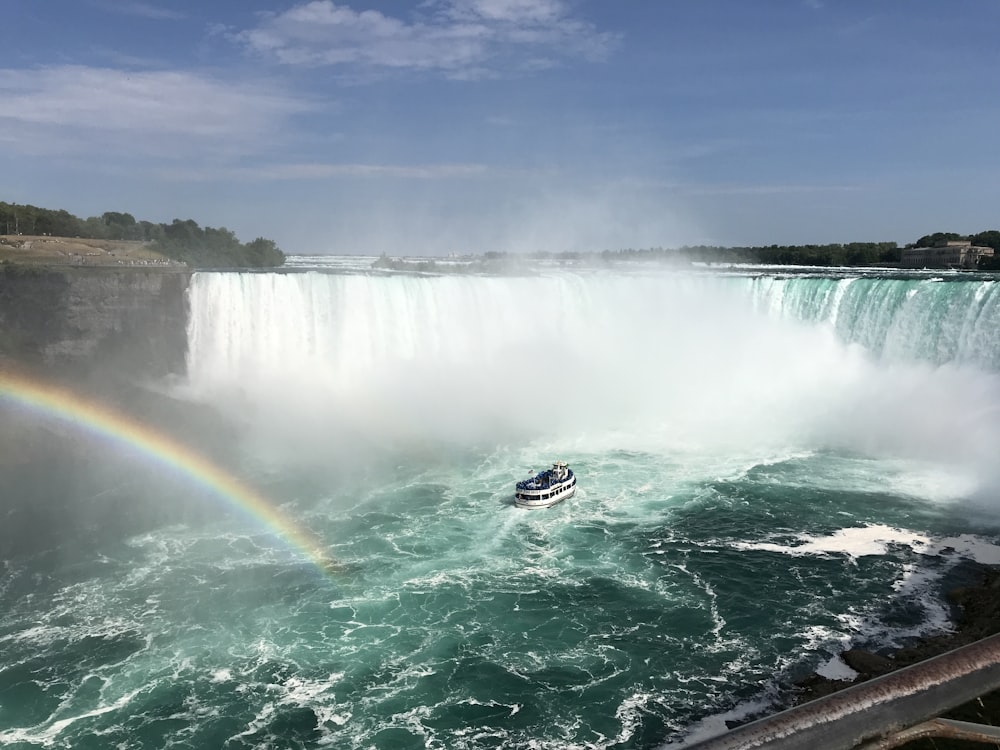 white boat on water falls during daytime