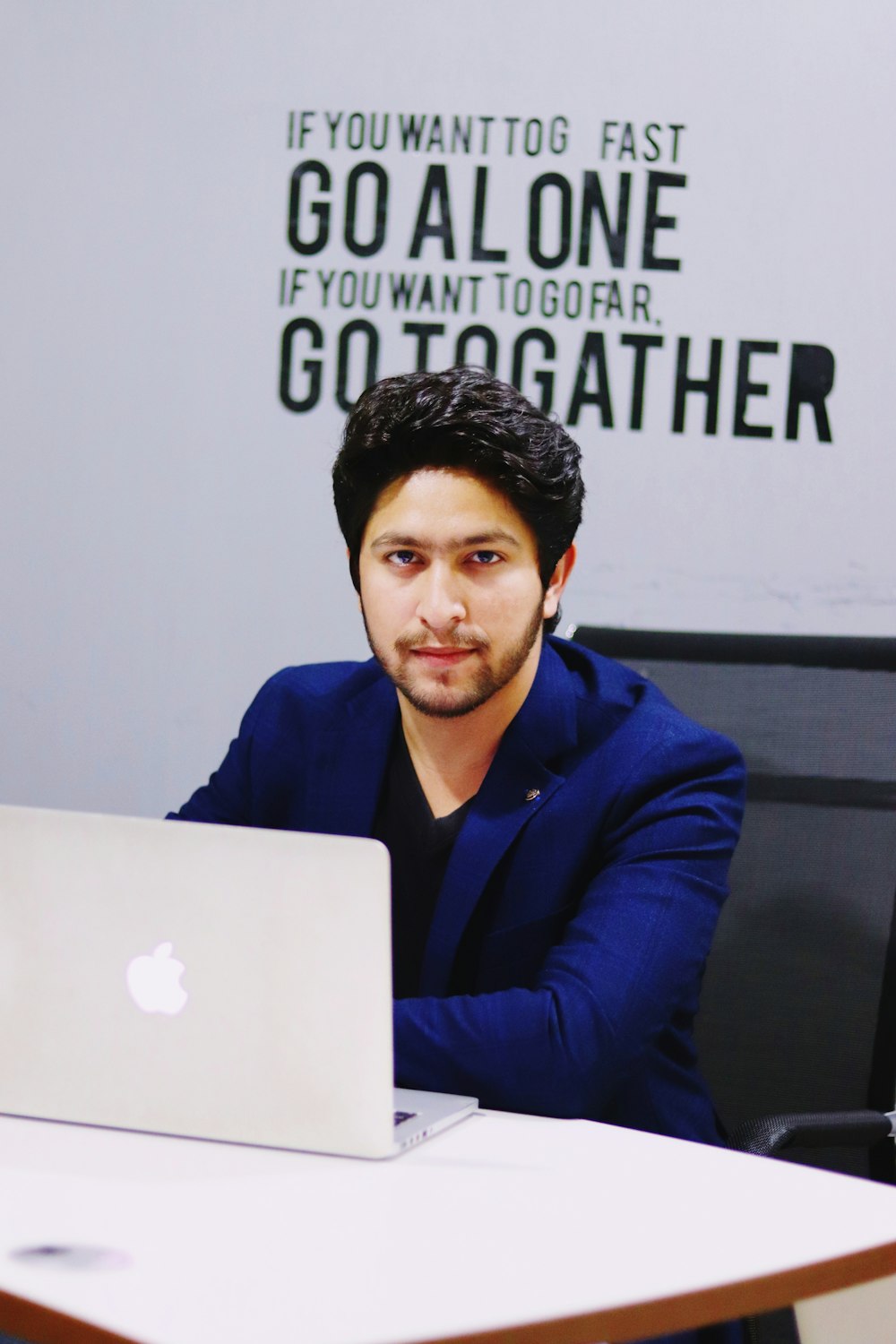 man in blue jacket sitting by the table