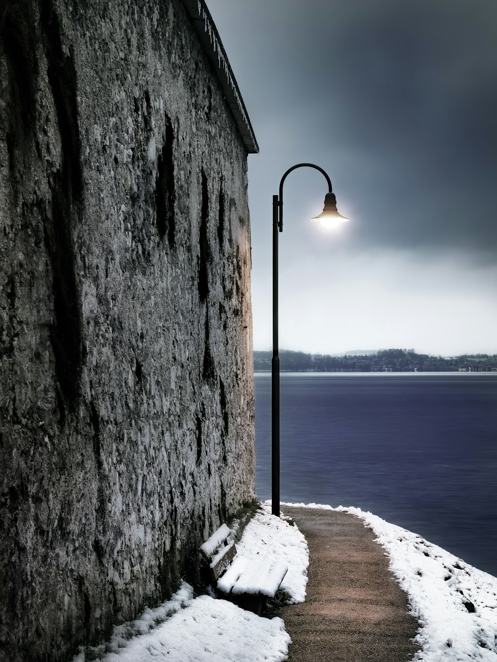 lampadaire noir près d’un plan d’eau pendant la journée