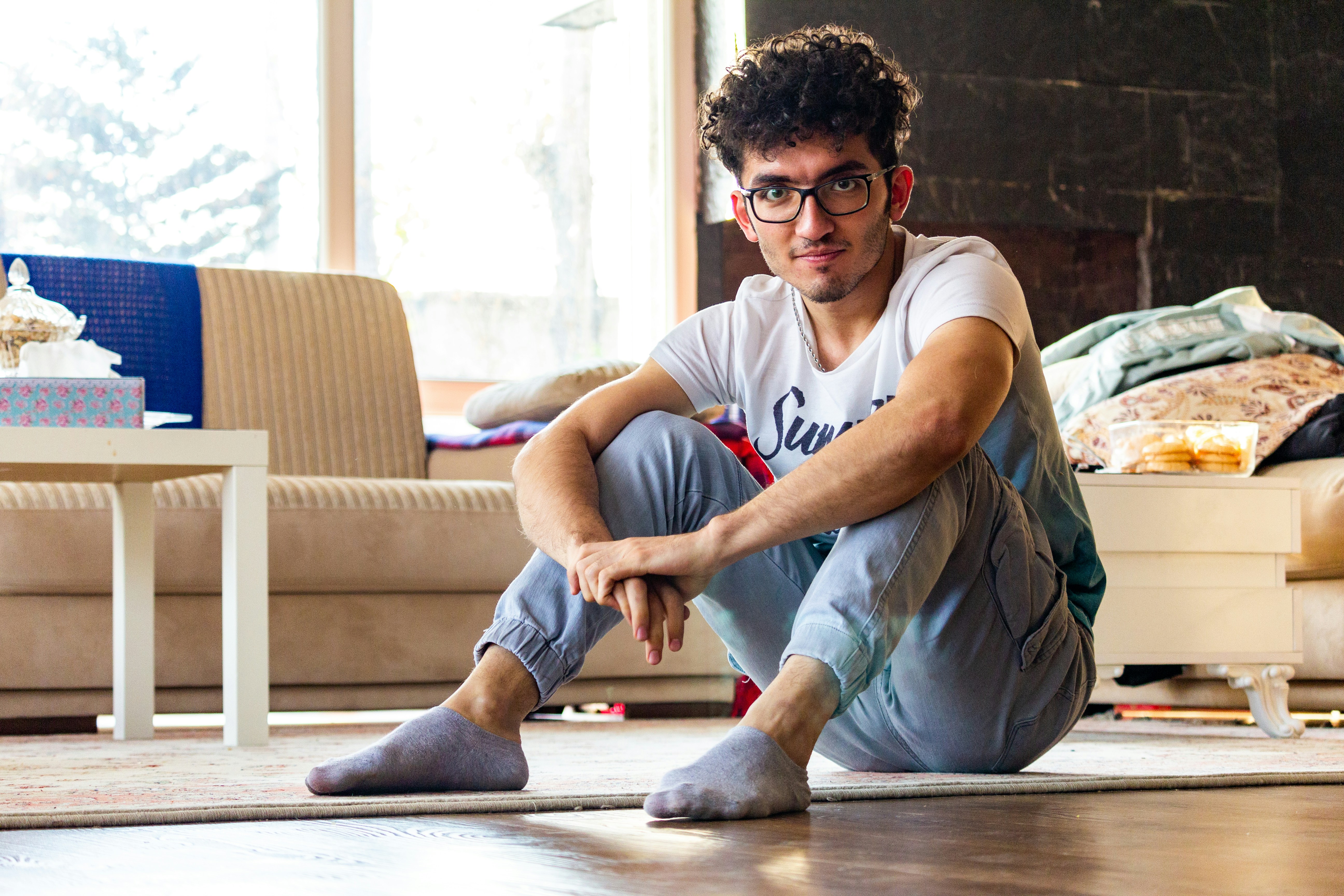 Un homme assis par terre dans un salon