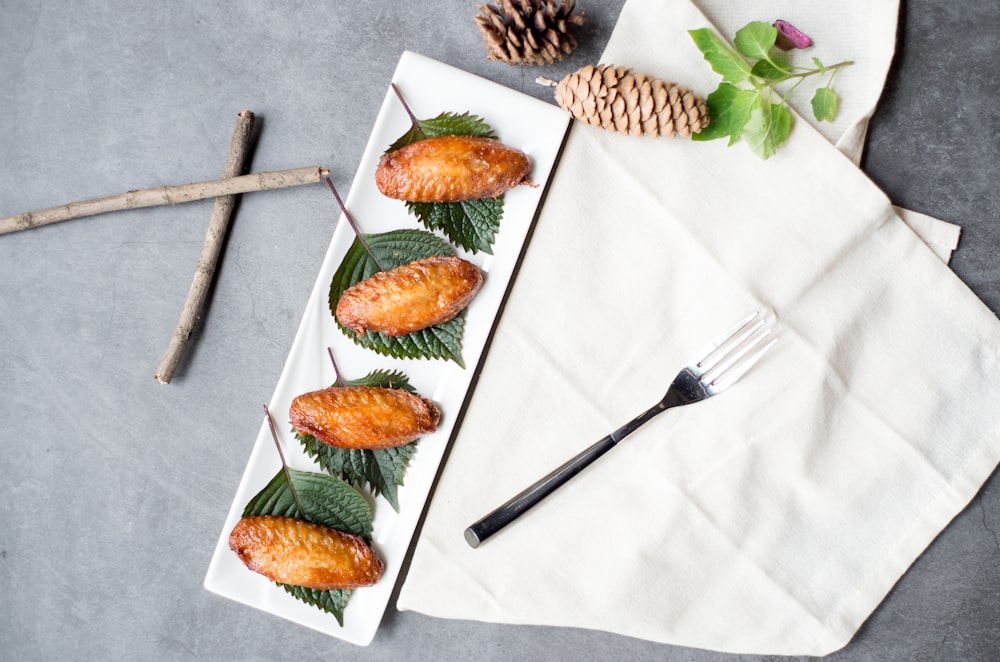 stainless steel fork and bread knife on white textile