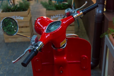 Close-up of a lightweight electric scooter's handlebar and display panel in bright daylight.