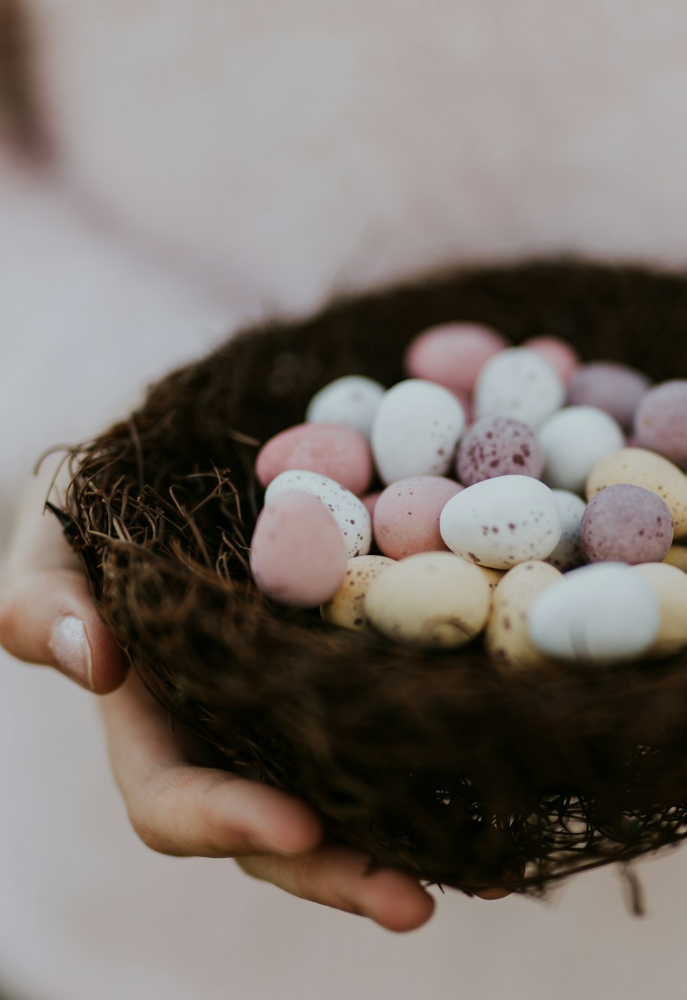 white and pink egg on brown nest