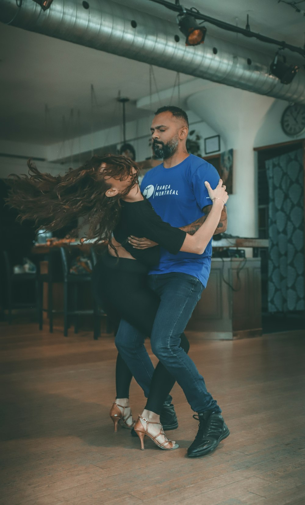 man in blue crew neck t-shirt and blue denim jeans sitting on brown wooden floor