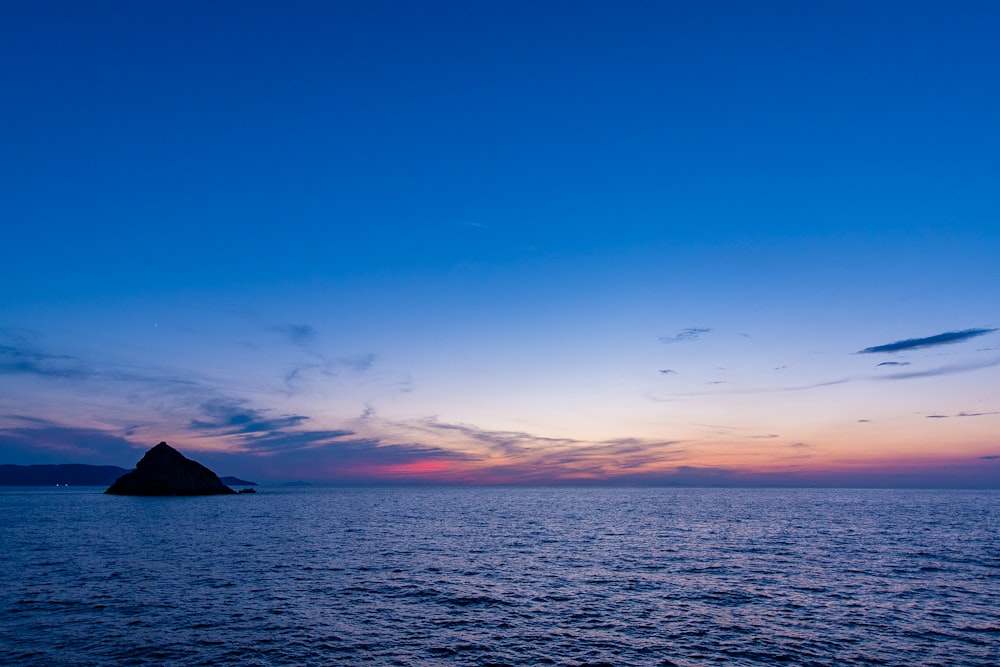 Cuerpo de agua bajo el cielo azul durante la puesta del sol