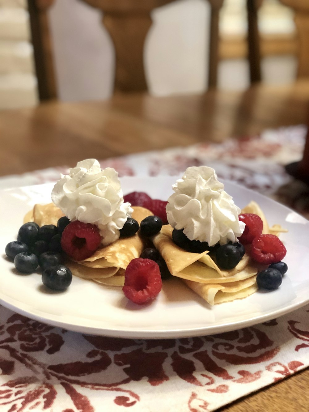 white and red ceramic plate with white cream and black berries