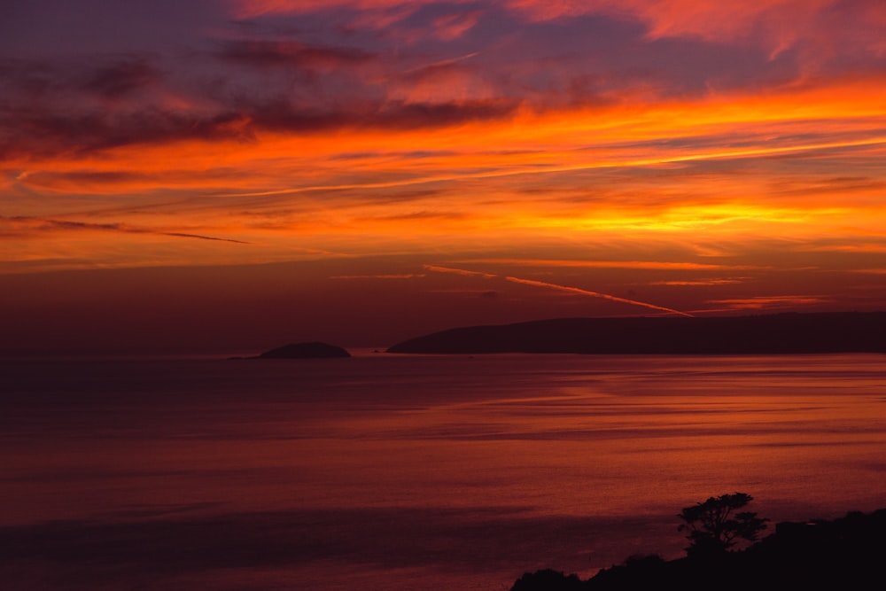 body of water under cloudy sky during sunset