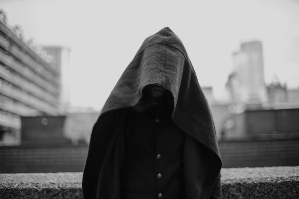 Foto en escala de grises de una persona cubierta con una manta