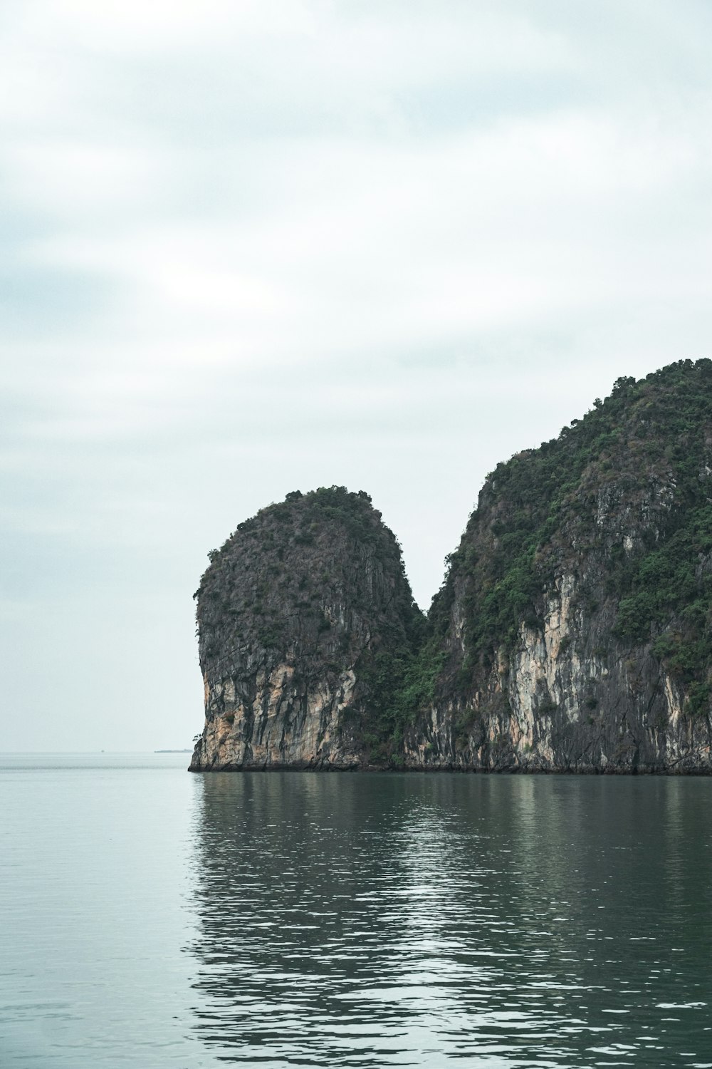 green and brown mountain beside body of water during daytime