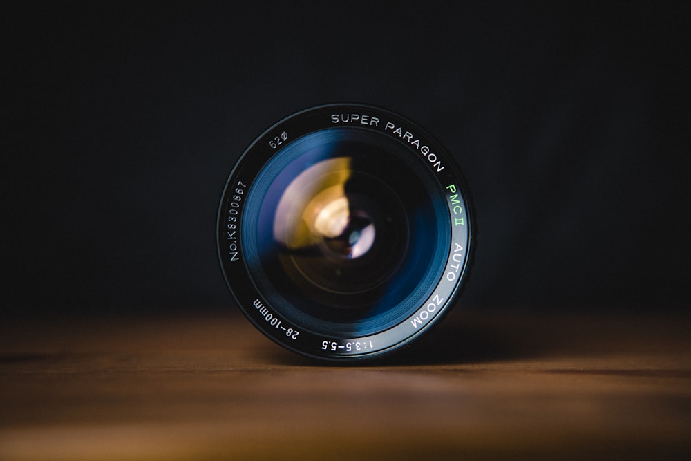 black camera lens on brown wooden table