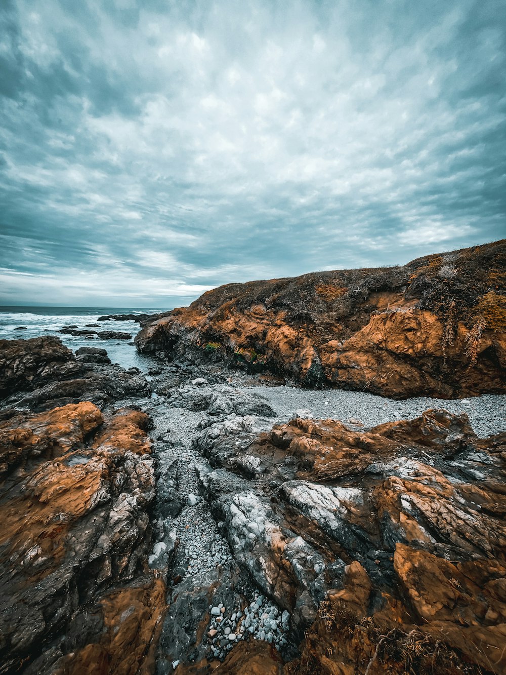 brown rock formation near body of water during daytime