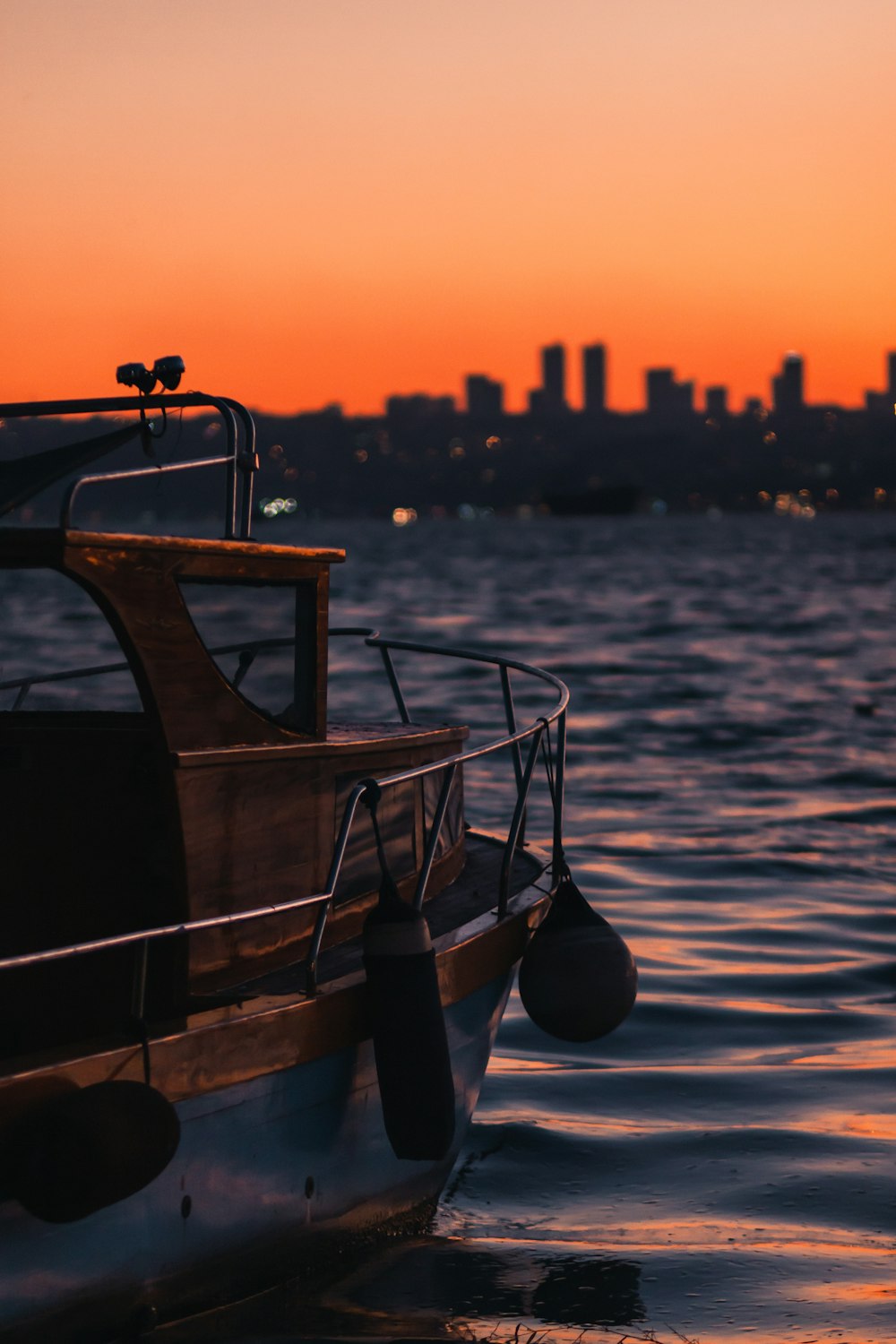 brown wooden boat on sea during sunset