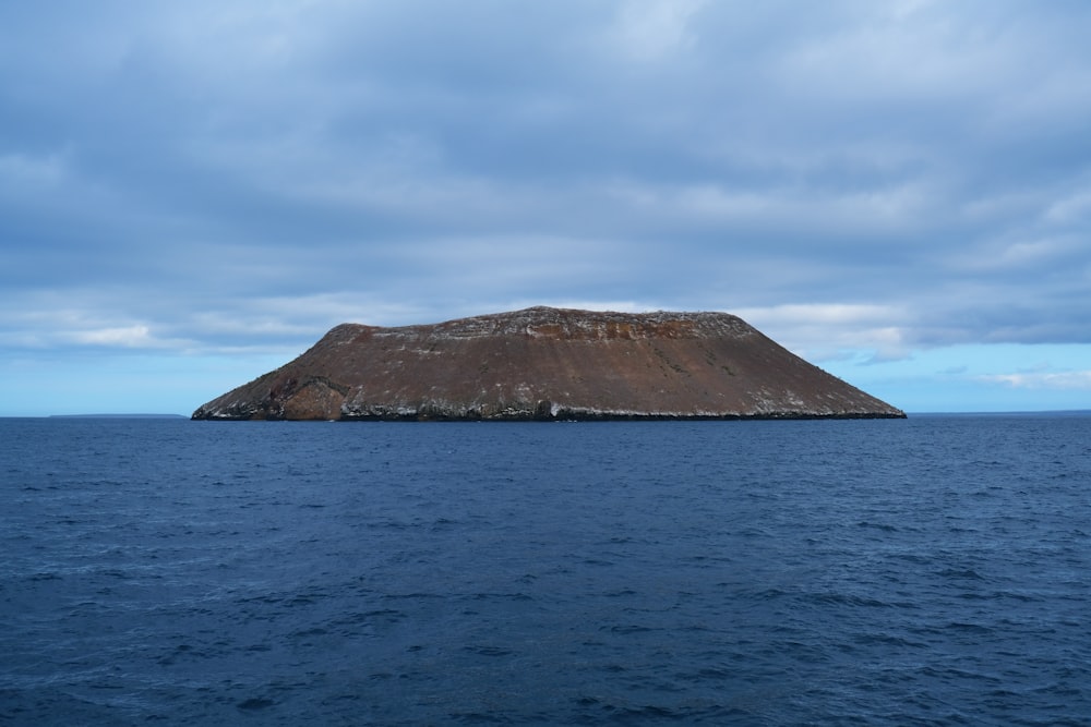 brown mountain near body of water during daytime