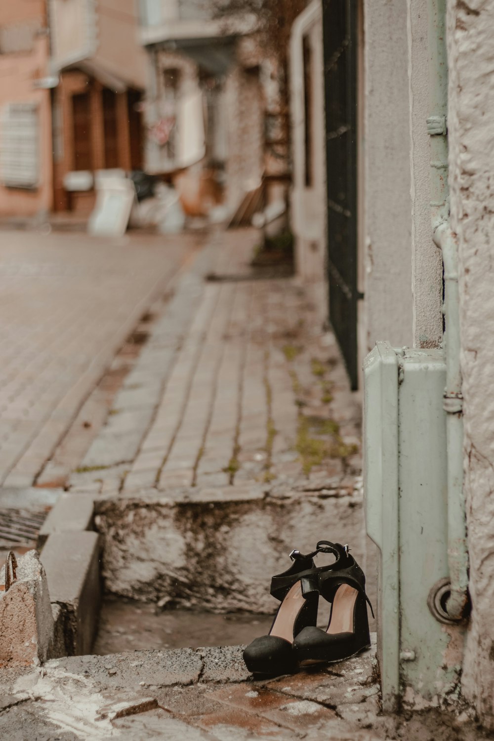 persona in scarpe nere in piedi sul marciapiede durante il giorno