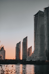 High-rise modern Dubai apartment building with waterfront view at sunset.