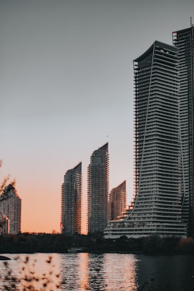 High-rise modern Dubai apartment building with waterfront view at sunset.