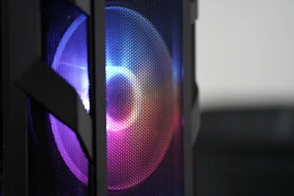 Close-up of a 3D printed crimson fan cover with intricate geometric patterns glowing softly under RGB lighting.