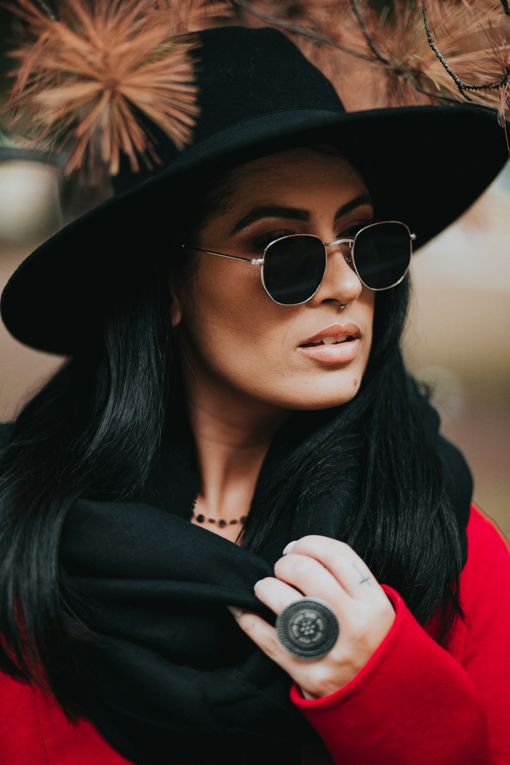 Femme en chapeau de soleil noir et chemise rouge portant des lunettes de soleil aviateur