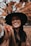 smiling woman wearing black hat and brown scarf