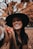 smiling woman wearing black hat and brown scarf