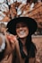 smiling woman wearing black hat and brown scarf