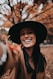 smiling woman wearing black hat and brown scarf