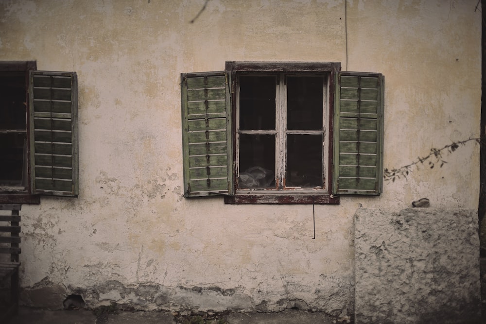 green wooden window frame on white concrete wall