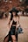 woman in brown blazer and black skirt wearing black hat