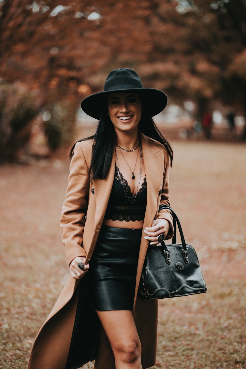 woman in brown blazer and black skirt wearing black hat