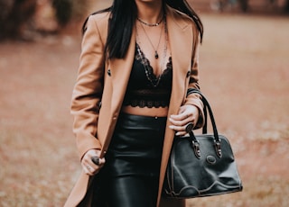 woman in brown blazer and black skirt wearing black hat