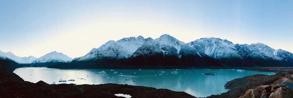 snow covered mountain near body of water during daytime