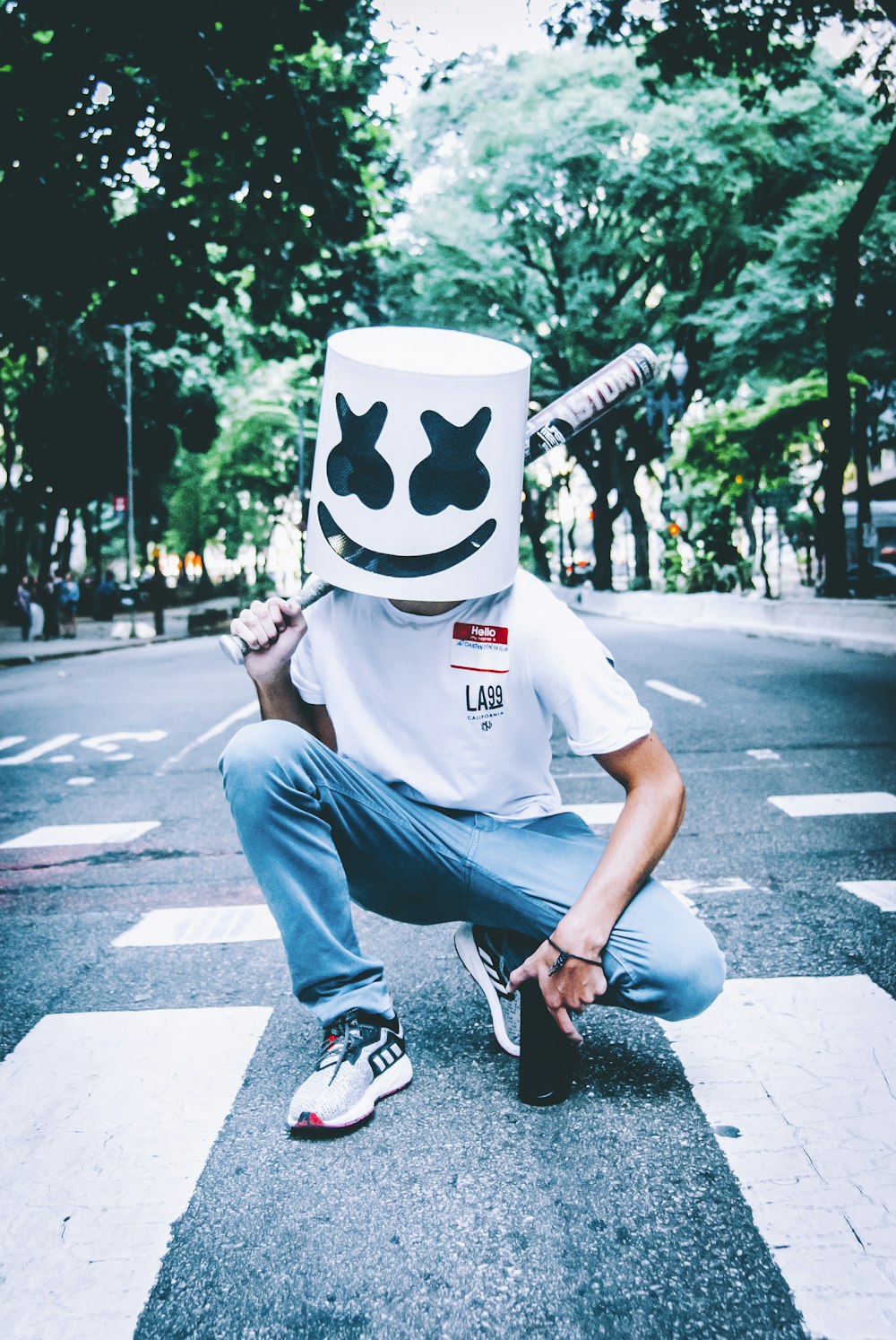 man in white crew neck t-shirt and blue denim jeans wearing white and black mask