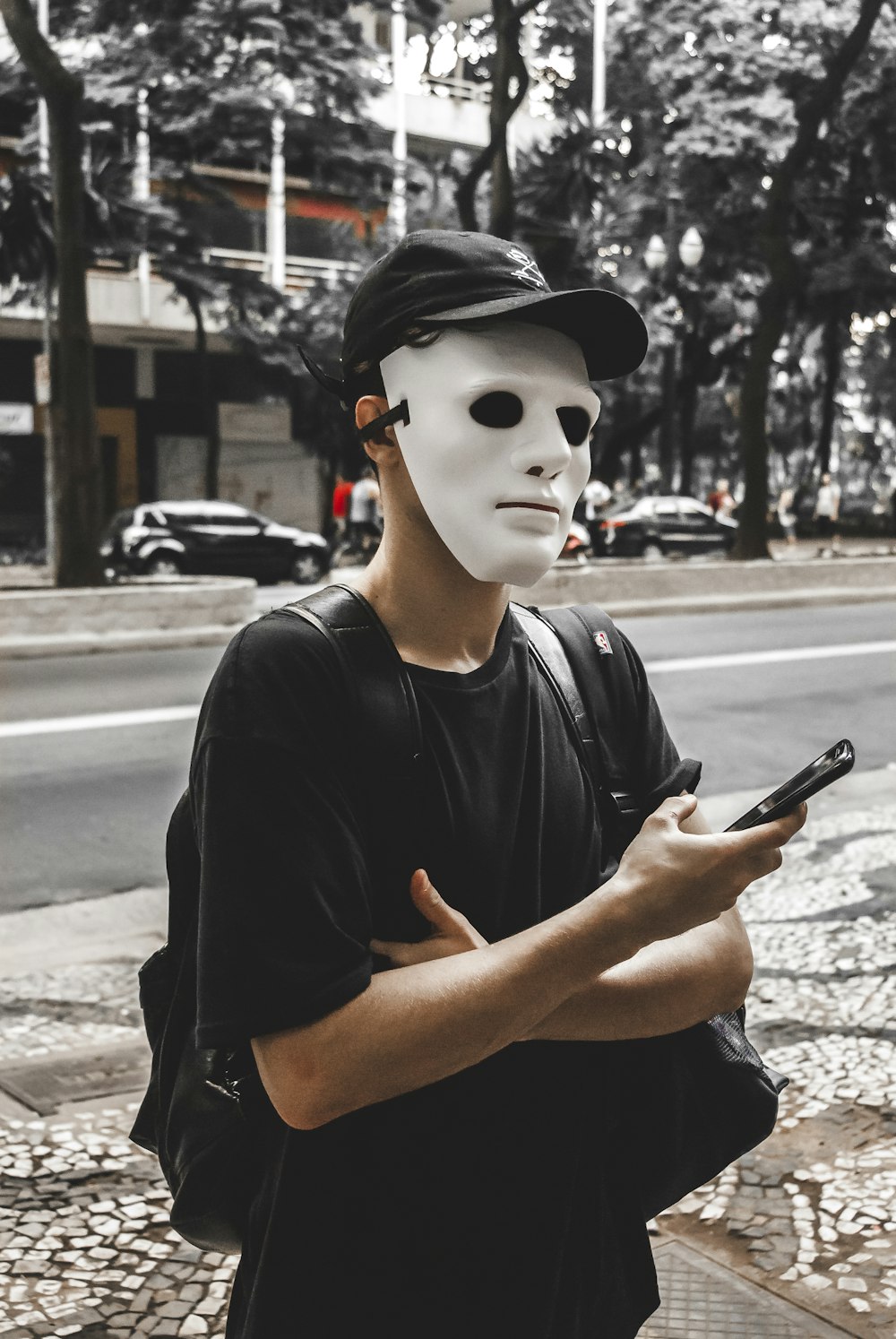 uomo in t-shirt girocollo nera che indossa maschera bianca