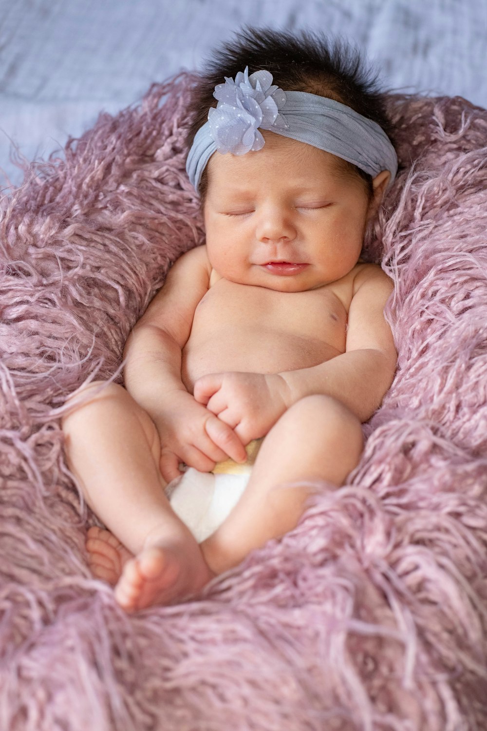 분홍색 직물에 누워있는 아기