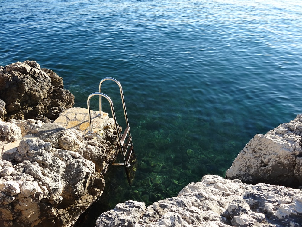 rochas cinzentas e castanhas ao lado do mar azul durante o dia