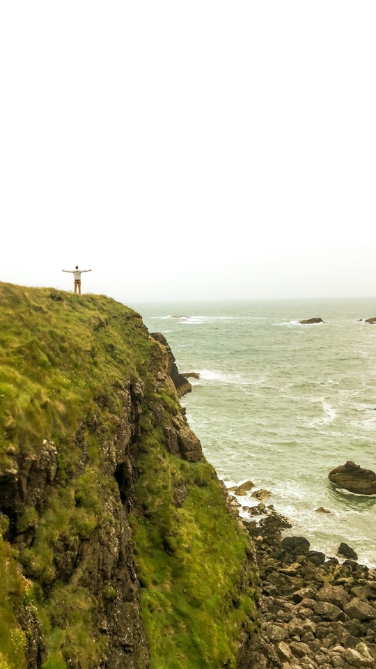 white cross on green mountain near body of water during daytime in Dunmore East Ireland