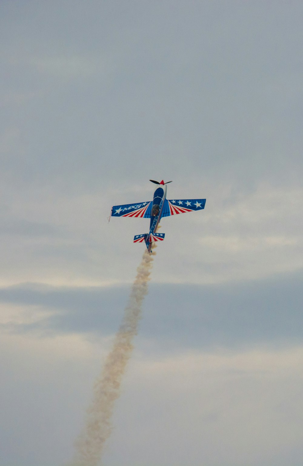 blue and red jet plane in mid air during daytime