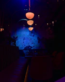 A glowing purple and blue gradient-lit dining area with futuristic glass tables and ambient lighting.
