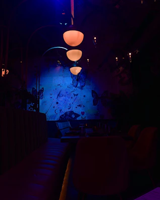 A glowing purple and blue gradient-lit dining area with futuristic glass tables and ambient lighting.