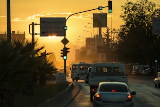 A Denizli city taxi parked near a busy university campus at sunset.