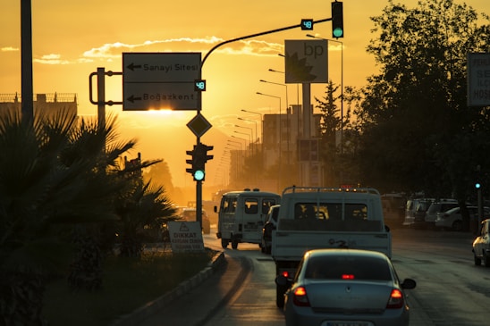 A Denizli city taxi parked near a busy university campus at sunset.