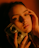 A person is holding a vintage twin-lens camera close to their face, with a soft and introspective expression. The lighting is warm and creates a moody, nostalgic atmosphere.
