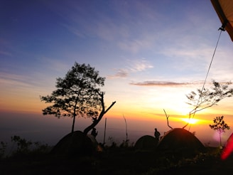 A serene sunrise over a peaceful camp surrounded by nature.